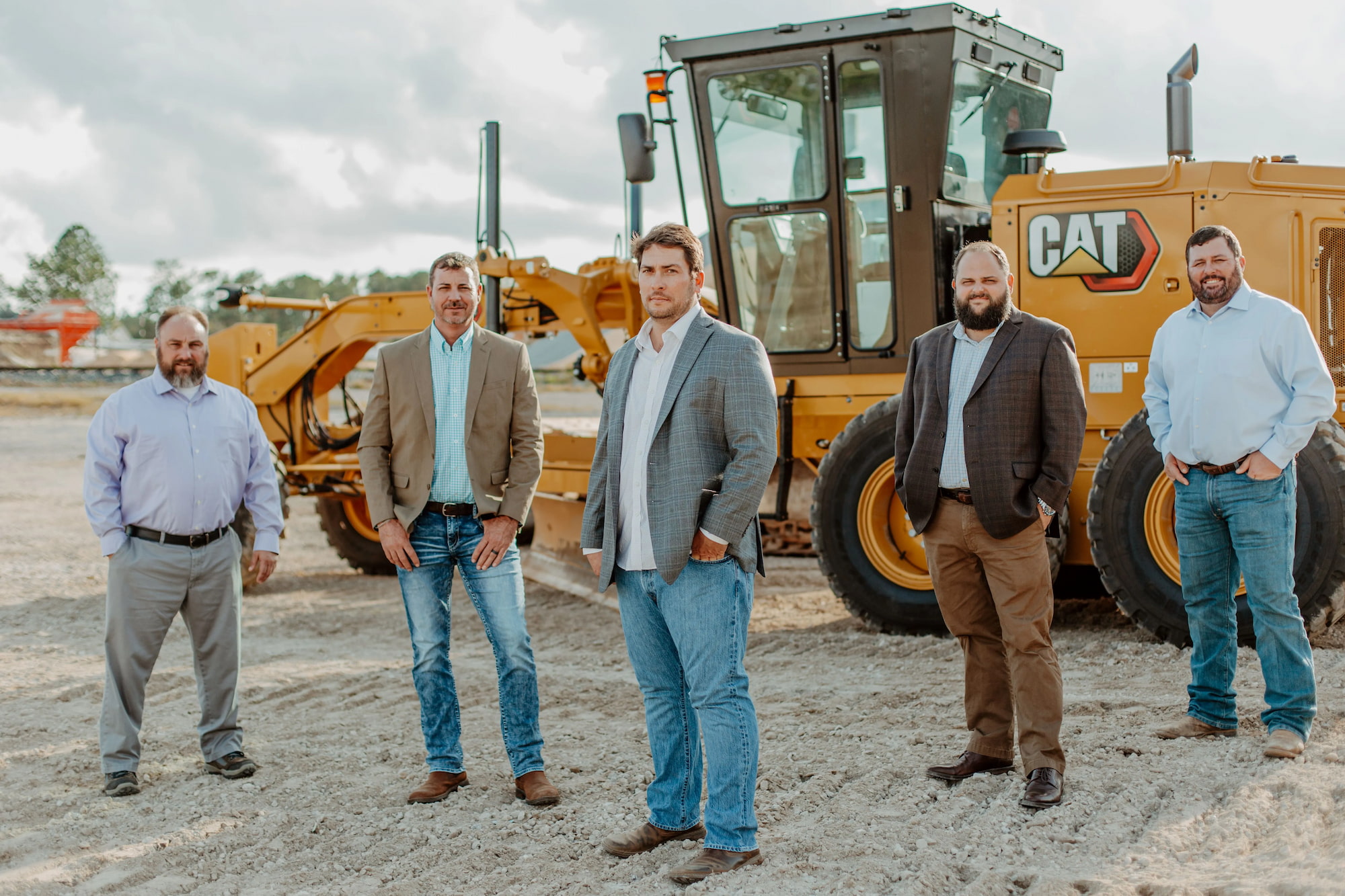 Patrick Davis stands with his employees in front of an excavator at Green Energy's headquarters in Holt, FL