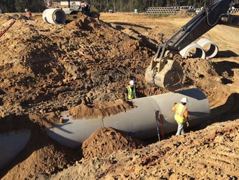 GEC employees laying underground utility pipe